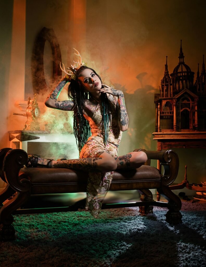 A woman in fantasy cosplay poses artistically indoors with dramatic lighting.